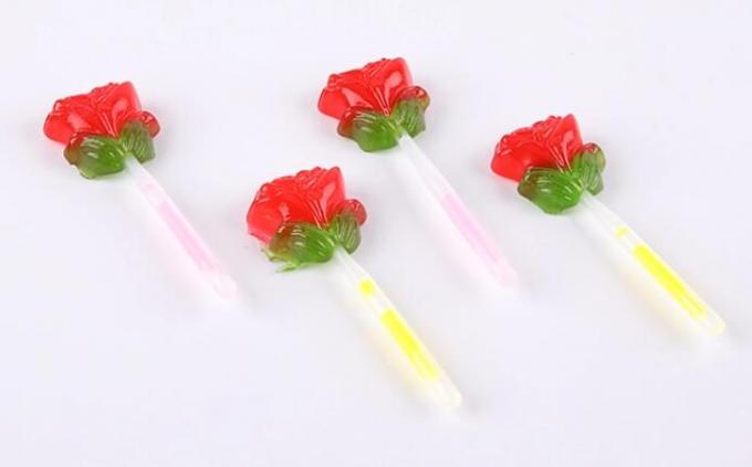 Флуоресцирование освещает вверх леденец на палочке формы цветка конфеты розовый с ручкой освещения